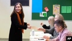Iceland's Prime Minister Katrin Jakobsdottir casts her vote at a polling station in Reykjavik, Sept. 25, 2021. An unprecedented number of political parties appeared likely to win parliamentary seats.