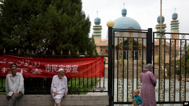 2014年7月17日，维吾尔族居民聚集在中国西部新疆阿克苏市的清真寺外。