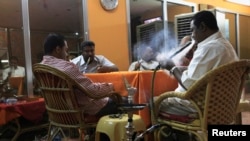 Customers smoke water pipes at a shisha cafe in Khartoum, April 28, 2013