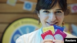 Joanna Choukeir shows some of the cards from a DIY Happiness card game, at the launch of 'Action For Happiness' encouraging meditation, hugging and kindness, in London, April 12, 2011.