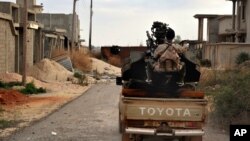 FILE - a man loyal to the Libyan armed forces prepares himself for clashes with Islamic State group militants west of Benghazi, Libya.