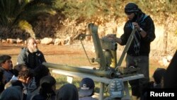 A Free Syrian Army trainer addresses fellow fighters as he conducts a demonstration on how to use anti-tank and anti-aircraft weapons at a training camp in the northern countryside of Aleppo March 31, 2014. Picture taken March 31, 2014. 