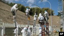 Workers attempt to repair power lines at the Fukushima Daiichi Nuclear Power Plant in Tomioka, Japan, March 24, 2011