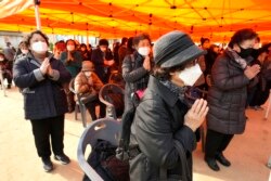 Parents pray during a special service to wish for their children's success in the College Scholastic Ability Test at the Jogyesa Buddhist temple in Seoul, South Korea, Thursday, Nov. 18, 2021.