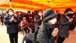 Parents pray during a special service to wish for their children's success in the College Scholastic Ability Test at the Jogyesa Buddhist temple in Seoul, South Korea, Thursday, Nov. 18, 2021.