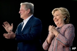 ຜູ້ສະໝັກະປະທານາທິບໍດີ ທ່ານາງ Hillary Clinton ຕິດຕາມດ້ວຍ ອະດີດຮອງປະທານາທິບໍດີ ທ່ານ Al Gore ຢູ່ເທິ້ເວທີໂູຄສະນາຫາສຽງ.