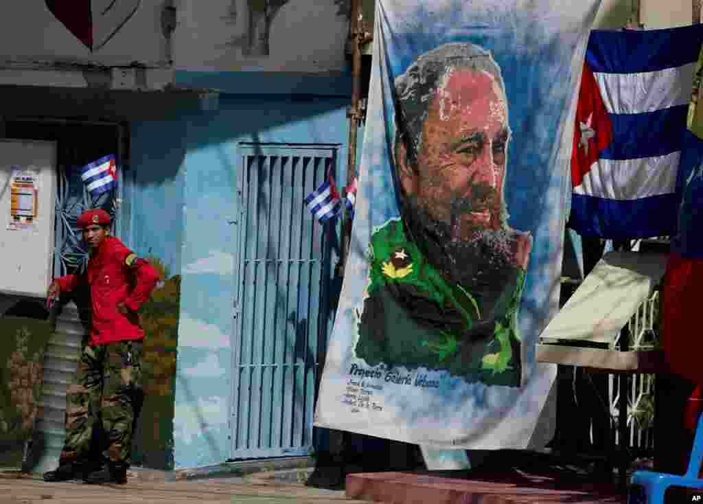 Un miembro de la milicia venezolana está al lado de una bandera de Fidel Castro en el barrio 23 de Enero de Caracas, Venezuela, el sábado 26 de noviembre de 2016. 