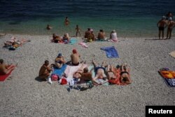 People sunbathe on a beach in Koktebel, southern Crimea, July 23, 2016.