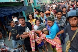 Myanmar, Mandalay, People pull out Shell Ye Win 24 who was shot during the security force crack down on anti-coup protesters