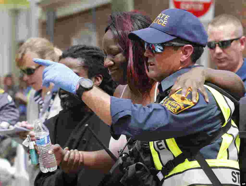 Rescue personnel help an injured woman after a car ran into a large group of protesters after an white nationalist rally in Charlottesville, Aug. 12, 2017.