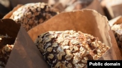 Bags of freshly-baked bread covered in oat flakes