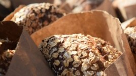 Bags of freshly-baked bread covered in oat flakes