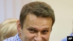 Lidè opozisyon ris Alexei Navalny ap souri pandan lap tande jij la nan yon tribinal nan vil Kirov, nan Larisi (Foto: 18 jiyè, 2013). 