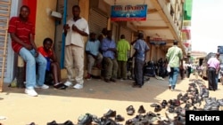 FILE - In an earlier tax protest, vendors sell used shoes on the street outside their shops in Kampala, Uganda, June 28, 2013. 