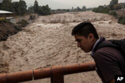 A man looks at the flow of the Huaycoloro river in Lima, Peru, March 16, 2017.