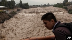 A man looks at the flow of the Huaycoloro river in Lima, Peru, March 16, 2017. 