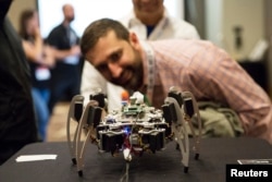 FILE - Visitors explore a robot equipped with facial recognition software at the South by Southwest (SXSW) interactive, film and music conference in Austin, March 17, 2015.