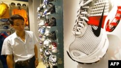 资料照：上海一家商场里一名顾客走过美国运动服装公司产品耐克鞋旁。