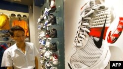 上海一家商場裡一名顧客走過美國運動服裝公司產品耐克鞋旁。