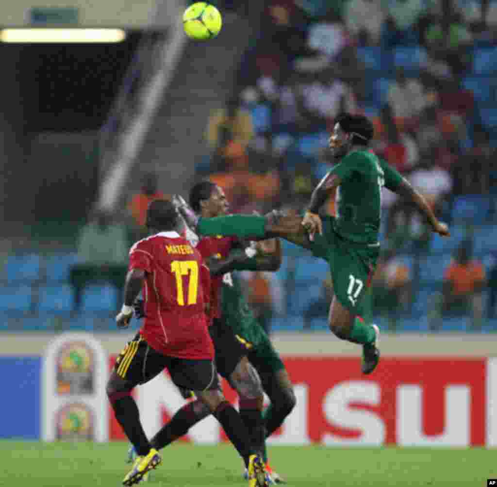 Paul Kebe Koulibaly, do Burkina Faso e Mateus Galiano disputam o esférico, durante o primeiro jogo das Palancas Negras, no CAN 2012, no Estádio de Malabo, a 22 de Janeiro