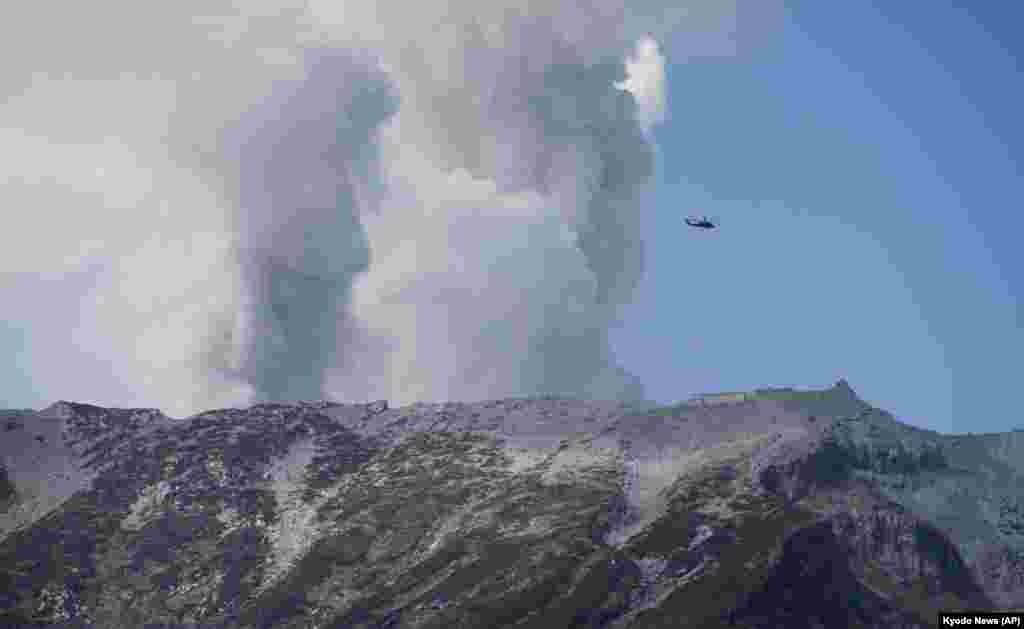 A military helicopter, aiding in rescue operations, flies above Mount Ontake as it continues to erupt in Nagano prefecture, Sept. 28, 2014.