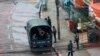 Police security forces stand by inside a police vehicle and on the sidewalk of Hledan Road in Kamayut township in Yangon, Myanmar Friday, April 16, 2021. 