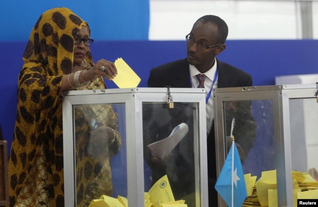 FILE - A Somali lawmaker casts her ballot during the presidential vote at the airport in Somalia's capital Mogadishu, Feb. 8, 2017.