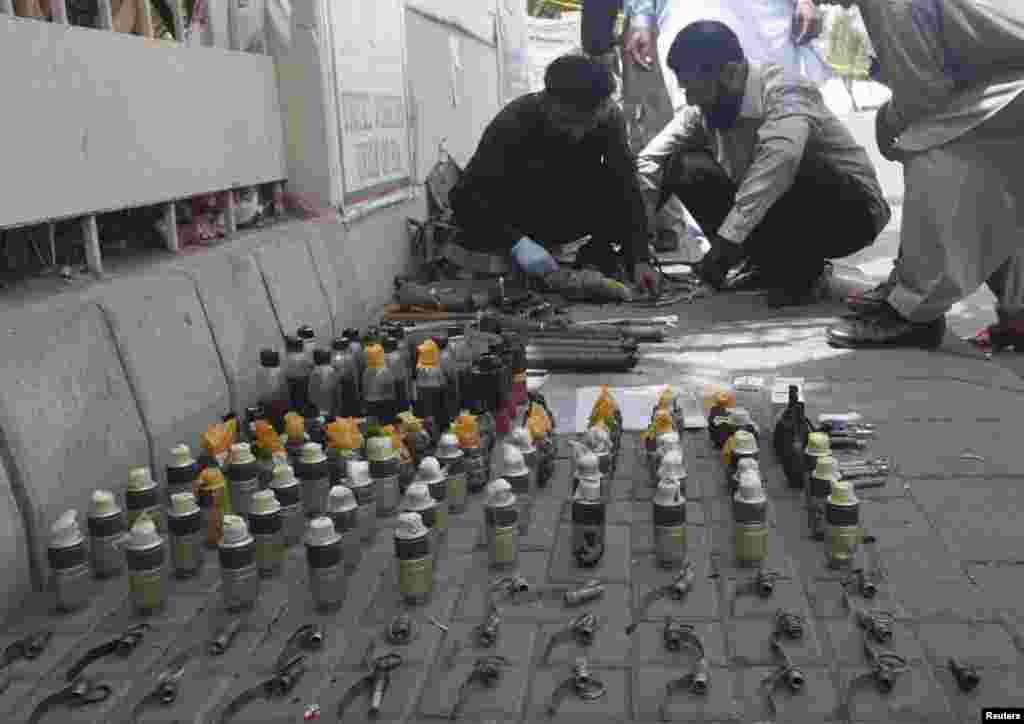 Members of the Bomb Disposal Squad defuse explosives and hand grenades along a sidewalk outside Jinnah International Airport in Karachi, Pakistan, June 9, 2014.