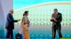 Singapore's Prime Minister Lee Hsien Loong, right gestures to Myanmar's Foreign Minister Aung San Suu Kyi, to move in closer for the group hand shake as Malaysia's Prime Minister Najib Razak, left, watches during the opening ceremony of the 28th and 29th ASEAN summits at National Convention Center in Vientiane, Laos, Tuesday, Sept. 6, 2016. 