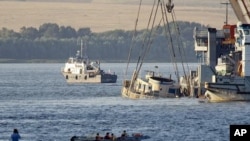 Cranes transport the Bulgaria sunken tourist boat, the upper deck of which is seen above the waters of the Volga river, during an operation, realized by Russian Emergencies Ministry, July 23, 2011