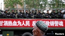 乌鲁木齐的街道上，维吾尔人开着卡车上的武警，卡车上的标语说“甘洒热血为人民”
