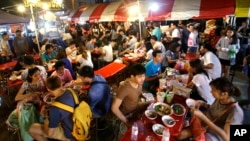 FILE - In this Thursday, Oct. 22, 2015 photo, customers eat Bamee Jom Palang, or "Power Noodles", at one of the most crowded food stalls at Rotfai Market in Bangkok, Thailand. (AP Photo/Sakchai Lalit)