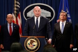 Acting Attorney General Matt Whitaker, center, with Commerce Secretary Wilbur Ross, left, and FBI Director Christopher Wray speak, Jan. 28, 2019, at the Justice Department in Washington during an announcement of an indictment on violations including bank and wire fraud of Chinese telecommunications companies including Huawei.