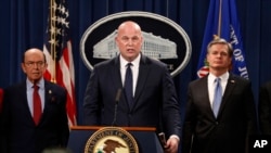 Le ministre américain de la justicepar intérim, Matt Whitaker, au centre, avec le secrétaire au Commerce, Wilbur Ross, à gauche, et le directeur du FBI, Christopher Wray, lors d'une conférence de presse le 28 janvier 2019 au Département de la justice à Washington.