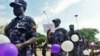 Ugandan police hold balloons and signs condemning violence against women, Kampala, Uganda, Dec. 5, 2015.