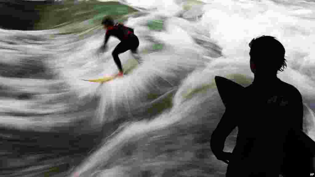 A surfer rides a wave on the river Eisbach in the English Garden in downtown Munich, southern Germany.