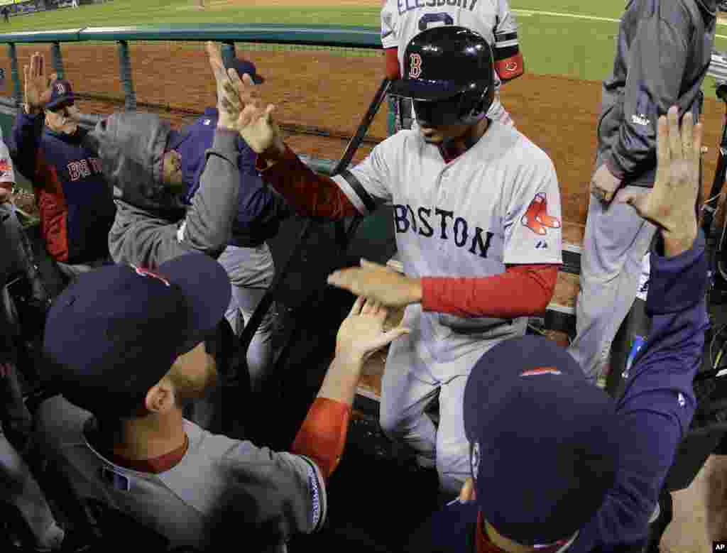 Boston Red Sox shortstop Xander Bogaerts is congratulated by teammates after scoring on a David Ross RBI ground rule double to left field against the St. Louis Cardinals during the seventh inning of Game 5 of baseball's World Series, Oct. 28, 2013,