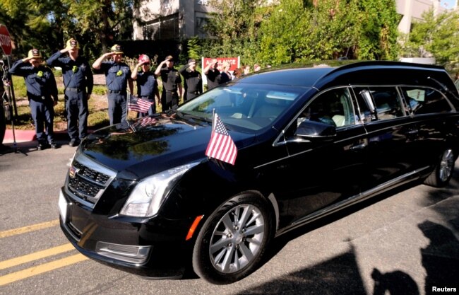 Law enforcement officers salute the hearse carrying the body of Ventura County Sheriff Sgt. Ron Helus, who was shot and killed in a mass shooting at a bar in Thousand Oaks, Calif., Nov. 8, 2018.