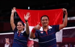 Hary Susanto dan Leani Ratri Oktila dari Indonesia merayakan kemenangan mereka melawan Lucas Mazur dan Faustine Noel dari Prancis di Paralympic Games Tokyo 2020. (Foto: REUTERS/Athit Perawongmetha)
