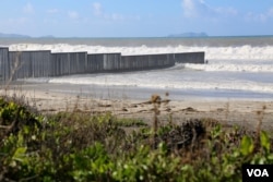 Waves break on the U.S.-Mexico border barrier at the edge of the Pacific Ocean. (R. Taylor/VOA)