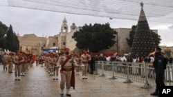 Palestinian scout band members parade through Manger Square at the Church of the Nativity, traditionally believed to be the birthplace of Jesus Christ, during Christmas celebrations, in the West Bank city of Bethlehem, Friday, Dec. 24, 2021.