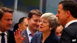 La primera ministra británico, Theresa May, coversa con el primer ministro holandés Mark Rutte, y el primer ministro de Luxemburgo, Xavier Bettel, durante una cumbre de la UE en Bruselas, el 21 de marzo de 2019.