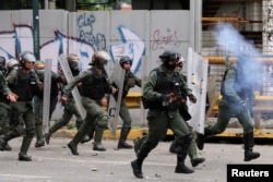 FILE - Security forces charge on anti-government protesters marching to the Supreme Court to support new magistrates named to the government-dominated Supreme Court by opposition-led led National Assembly, in Caracas, Venezuela, July 22, 2017.