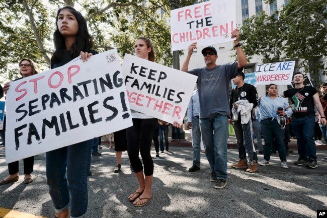 Protesters carry signs and chant slogans in front of Federal Courthouse in Los Angeles, June 26, 2018.