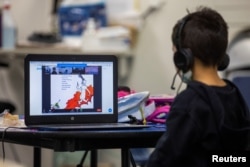 Daniel (5) menonton Dr. Seuss saat berlangsungnya kelas online melalui zoom di Westchester Family YMCA di tengah pandemi COVID-19 in Los Angeles, California, 2 Maret 2021.