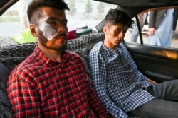 FILE - Afghan newspaper Etilaat Roz journalists Nematullah Naqdi (L) and Taqi Daryabi arrive at their office after being released from Taliban custody in Kabul, Sept. 8, 2021.