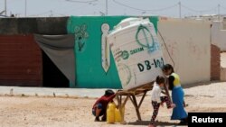 Syrian refugees children collect water at the Al-Zaatari refugee camp in Mafraq, Jordan, near the border with Syria, May 30, 2016.