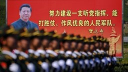 资料照：解放军士兵列队在中国领导人习近平画像前走过。（2015年8月22日）