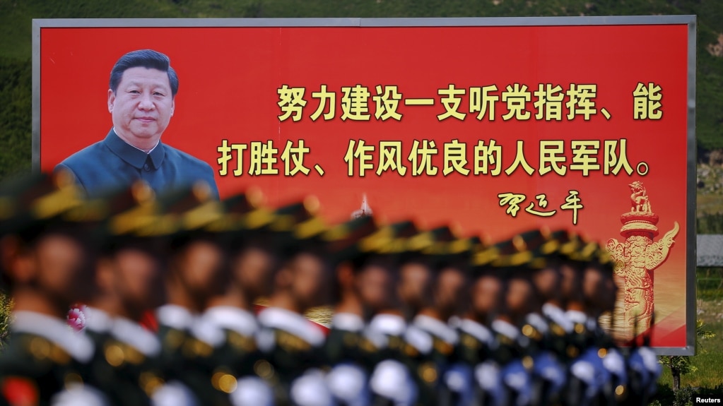 资料照：解放军士兵列队在中国领导人习近平画像以及他提出的“能打胜仗，作风优良”的口号前走过。（2015年8月22日）