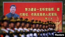 资料照：解放军士兵列队在有着中国领导人习近平画像的宣传牌前走过。（2015年8月22日）